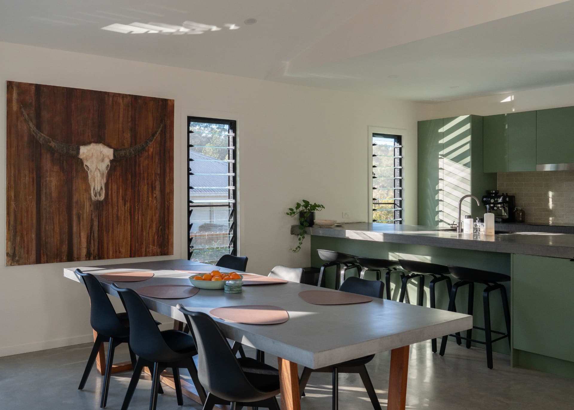 Renovated dining and sage green kitchen with concrete benchtops